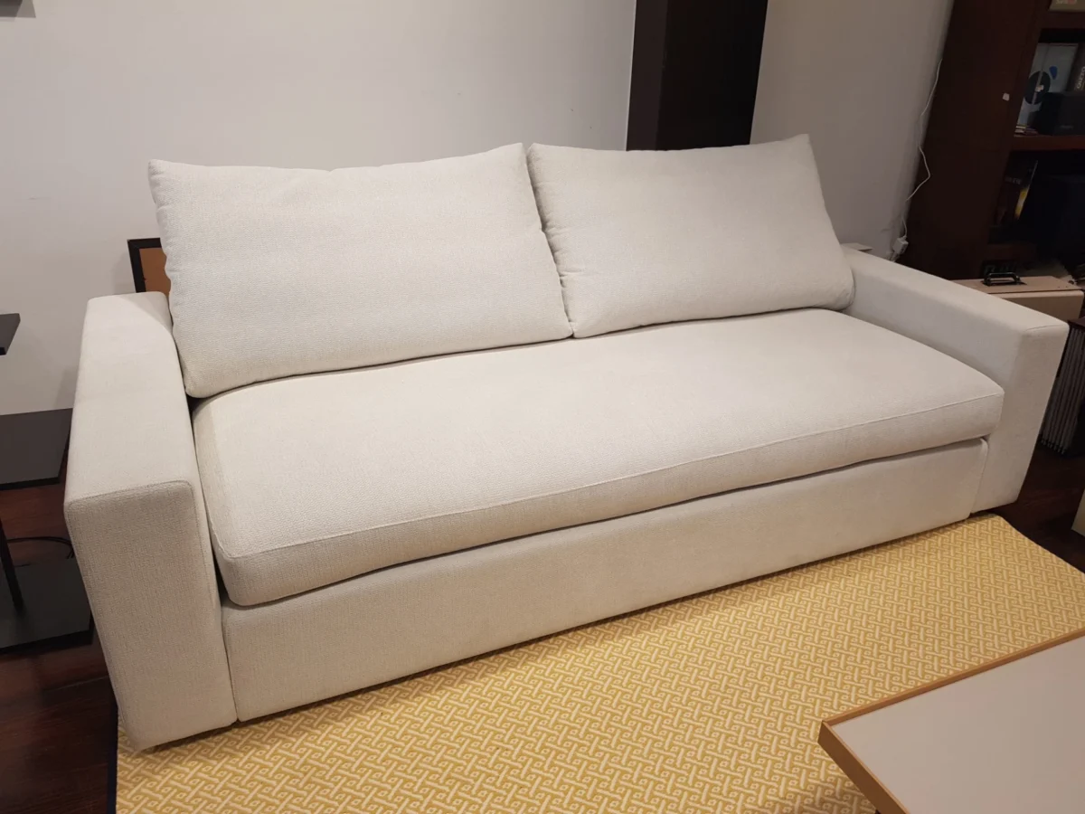 Sofá claro de brazos rectos en exposición