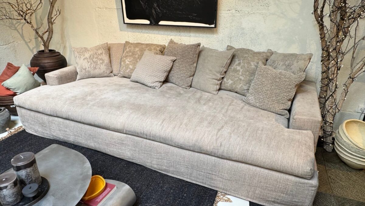 Sofá claro con cojines en un showroom